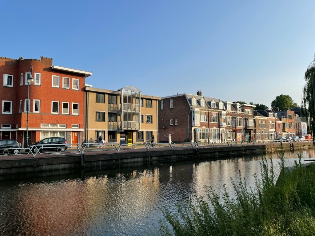 A body of water next to a row of buildings